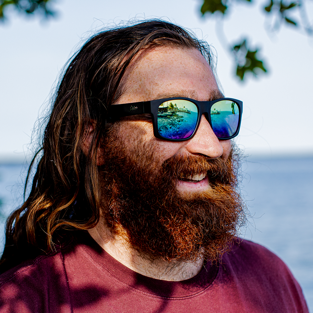 Snowboarder carving through powder in snowy terrain.