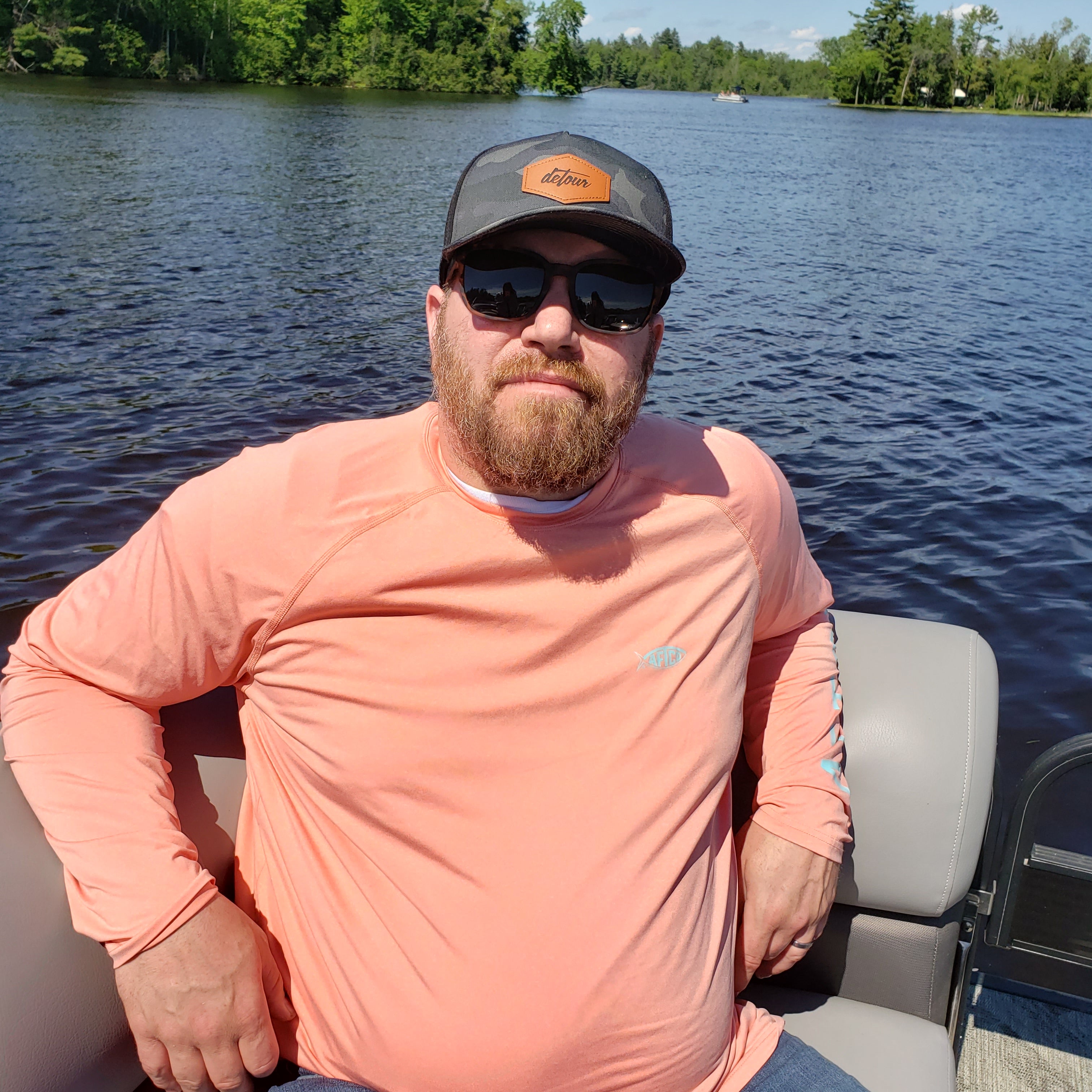 Man wearing mirrored goggles and gray beanie, holding skis in a snowy setting.