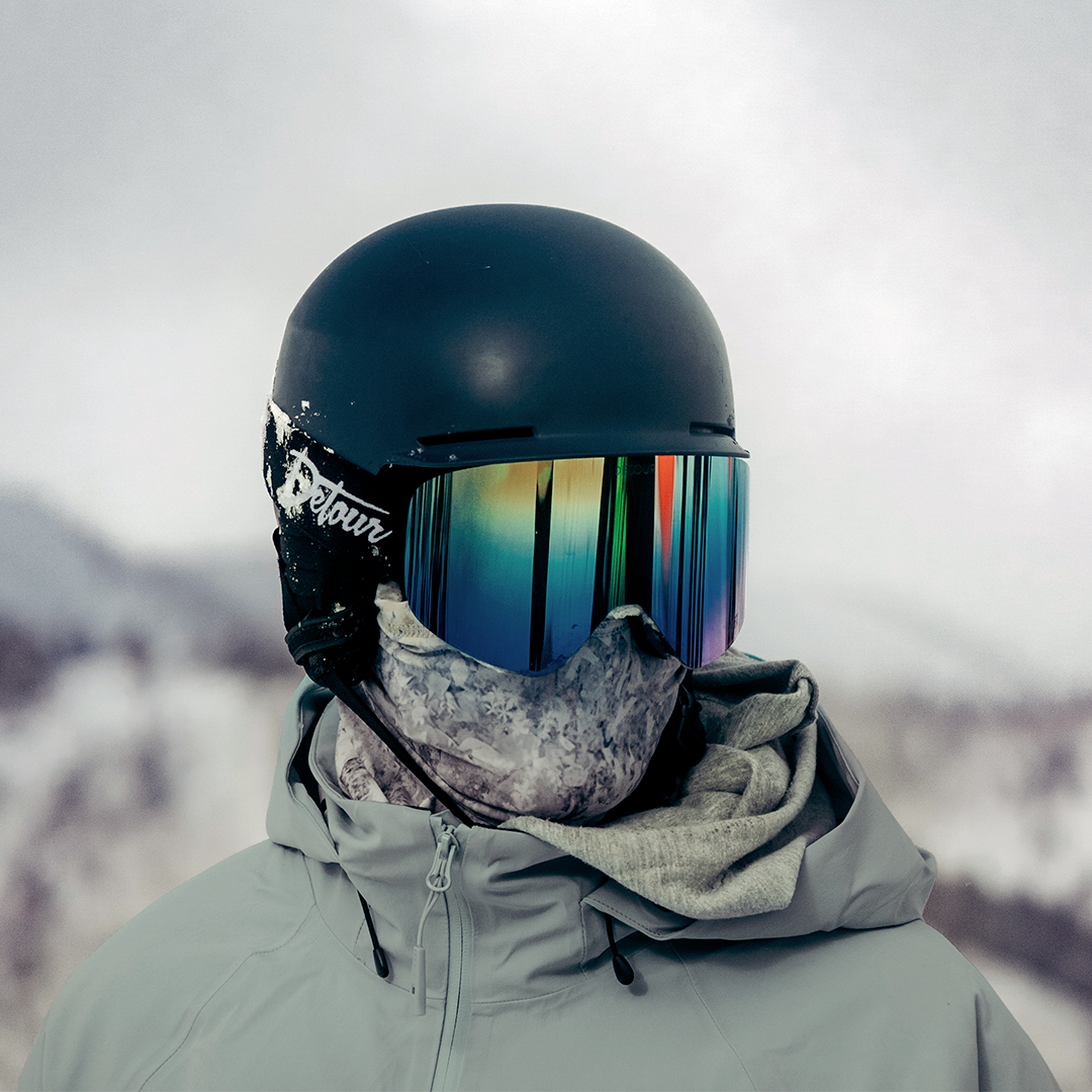 Person in snowboard gear with reflective goggles and helmet.