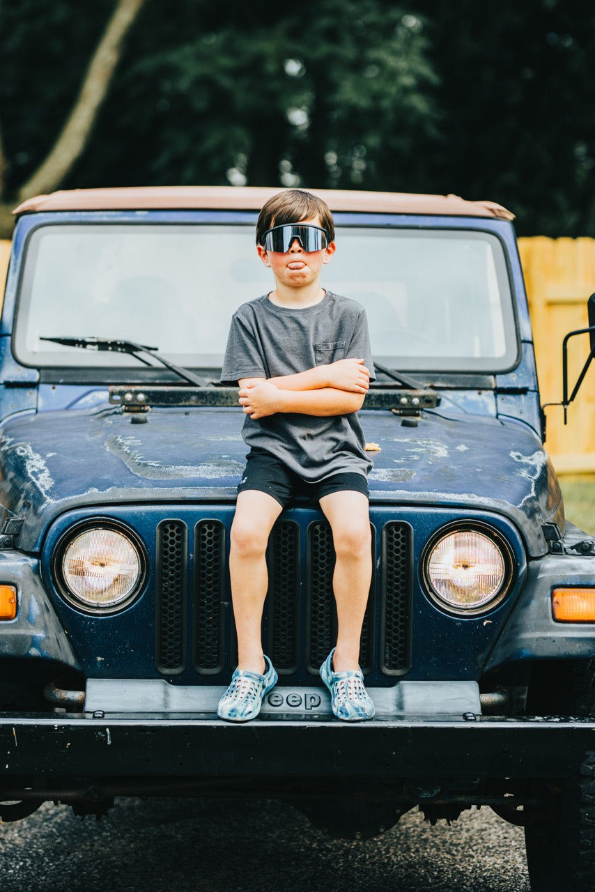 Snowboarder carving through powder in snowy terrain.